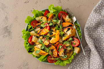 Light summer fresh salad with colorful tomatoes and croutons, lettuce and pineapple, sesame seeds...