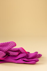 Pink microfiber cloth for washing and rubber gloves on a neutral beige background, cleaning concept