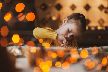 A cute sweet girl makes Christmas decorations from dried oranges, twigs and cones. Crafts for the holiday