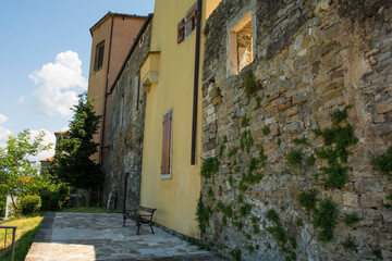 Fototapeta na wymiar Residential buildings which form part of the surrounding town walls in the historic medieval village of Buje in Istria, Croatia 