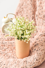 Vase with lily-of-the-valley flowers on chair