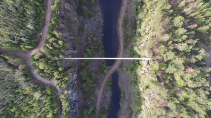 THUNDERBAY, CANADA - Jul 22, 2021: An aerial top view of a bridge through two mountains continuously ascending, Thunderbay, Canada