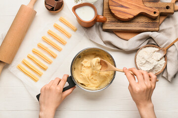 Woman making tasty churros on light wooden background