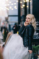 Portrait of young bride in black leather jacket on city street. New York, USA.