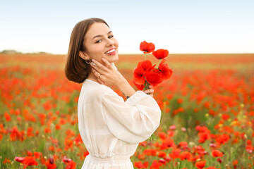 Beautiful young woman in poppy field