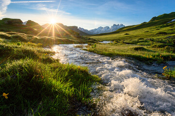 alpine creek at sunrise with peak of Titlis near Melchseefrutt in the swiss alps