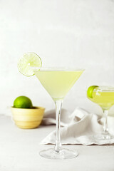 Glass with tasty daiquiri cocktail on light background