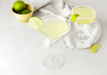 Glasses with tasty daiquiri cocktail on light background