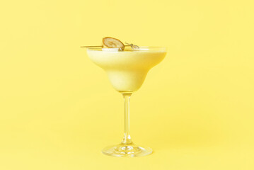 Glass of tasty banana daiquiri cocktail on color background