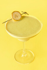 Glass of tasty banana daiquiri cocktail on color background