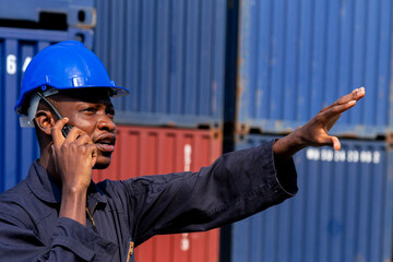 black african amarican man worker working control loading freight containers at commercial shipping...