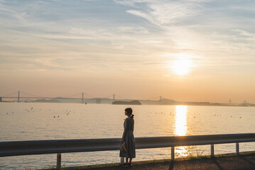 Fototapeta premium 夕暮れの海にいる女性