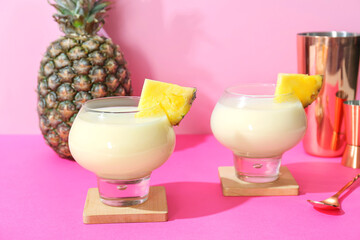 Glasses with tasty Pina Colada cocktail on color background