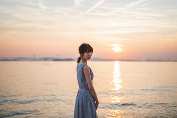 Fototapeta premium 夕暮れの海にいる女性
