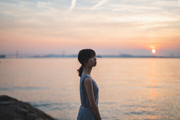 夕暮れの海にいる女性