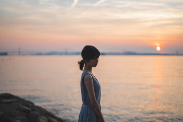 夕暮れの海にいる女性