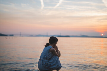 Fototapeta premium 夕暮れの海にいる女性