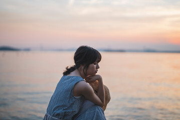 夕暮れの海にいる女性