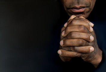 man praying to god with hands together Caribbean man praying on black background with people stock photos stock photo - obrazy, fototapety, plakaty