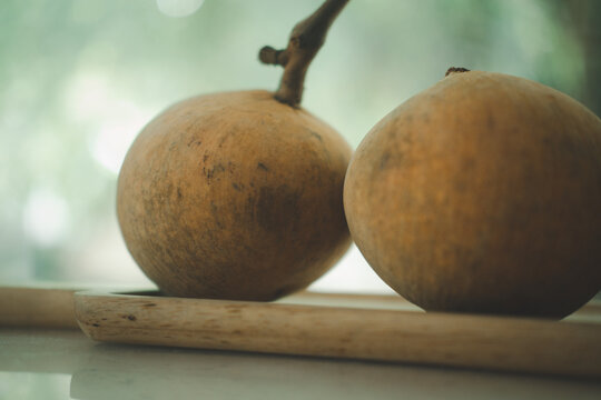 Santol fruits on a wood tray, Santol has a sour taste and the middle of santol is sweeter.