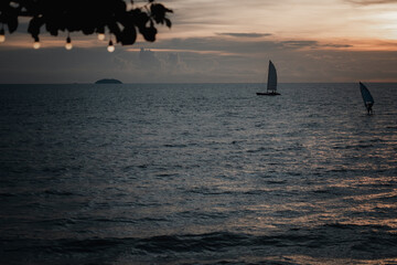 Scenic view with a sailboat moored off the shore against sky during sunset.