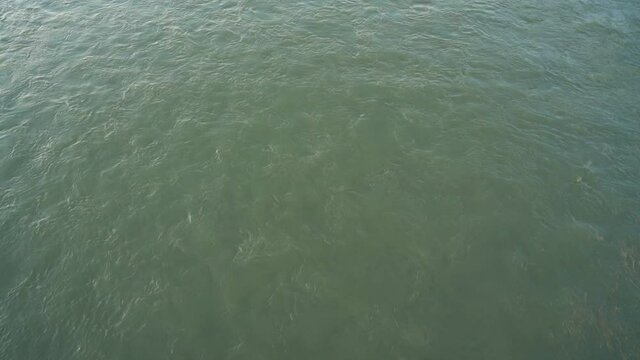 Fast muddy water stream flowing in large mountain river course view from above