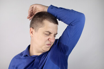 The man shows his sweaty armpits to the camera. Close-up of sweat drops. Gland problems....