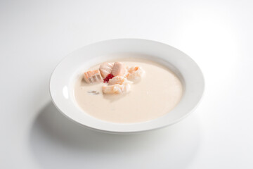 Fototapeta na wymiar Cream soup with salmon and shrimp isolated on white background