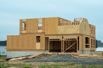 New residential construction home framing against a blue sky