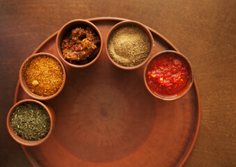 Georgian spices in clay jars on a plate.
