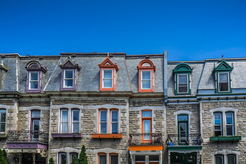 Typical house facades of Montreal Plateau Mont Royal neighborhood with colorful window frames