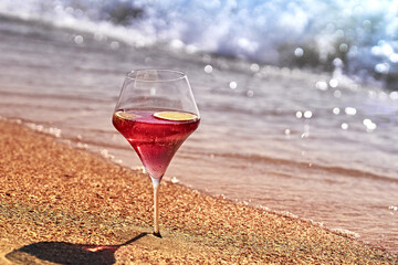 Wine glass with a cocktail by the sea.