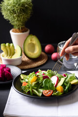 Fresh fruit and vegetable salad with avocado, dragon fruit, pumpkin, tomato, radish, lettuce and corn salad. Concepts of healthy food, vegetarian and lifestyle trends.