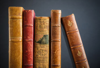 Row of old books on dark background