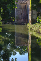 Quiet waters reflection on a canal of an old tower building