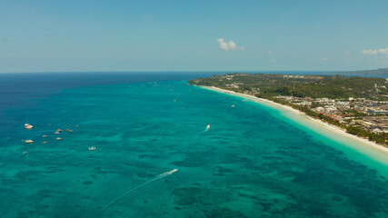 Tropical white beach with tourists and hotels near the blue sea, aerial view. Summer and travel vacation concept.