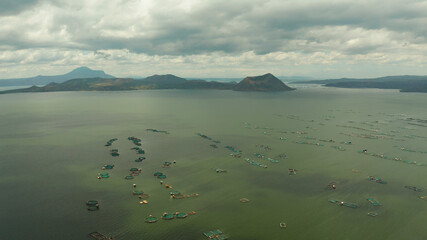 Lake Taal with a volcano and fish cages on a fish farm view from above. Luzon, Philippines Tropical landscape, mountains and volcano in the lake.