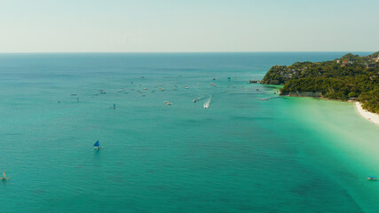 Tropical white sand beach with sailing yachts, hotels near the blue lagoon and corall reef. aerial view, Boracay, Philippines. Seascape with beach on tropical island. Summer and travel vacation