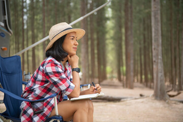 Woman looking at laptop near the camping. caravan car vacation. family vacation travel, holiday...
