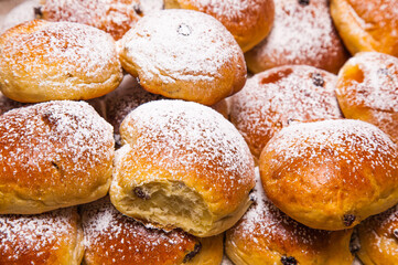 Bakery products. Buns with raisins covered with powdered sugar, close-up.