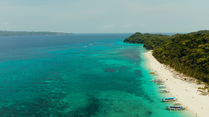 Aerial seascape: Tropical beach with palm trees and turquoise waters of the coral reef, from above, Puka shell beach. Boracay, Philippines. Seascape with beach on tropical island. Summer and travel