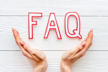 Hands with faq - frequently asked questions - paper letters, top view