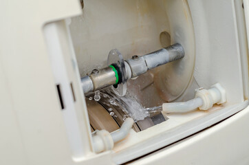 Making glasses. Machine for grinding and trimming eyepiece lenses in an optics store