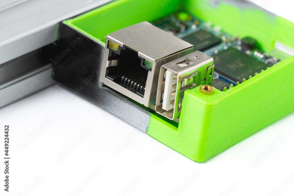 Poster close-up of orange pi in printed box on 3d printer isolated on white background.