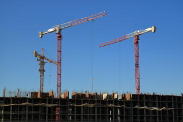 Tower cranes are working on the construction of a new house. Lifting crane.