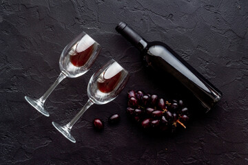 Two glasses of red wine with bottle and grape