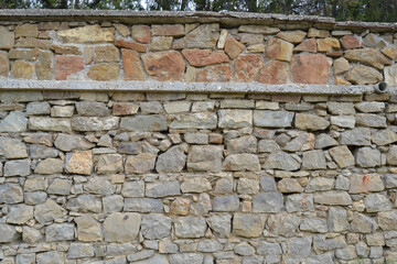 Texture of stone wall with mosaic tiles.