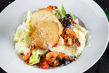 caesar with shrimps in a white plate close-up