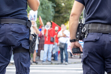 Police officers on duty during street protest, blurred protester in the background