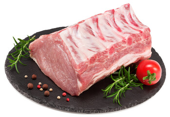 raw pork meat with rosemar, tomato and peppercorn on black round stone plate isolated on white background. Clipping path and full depth of field